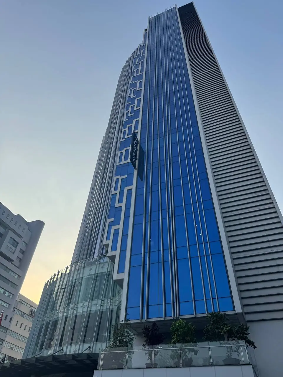세로 유리창과 노보텔 간판이 있는 고층 호텔 외벽