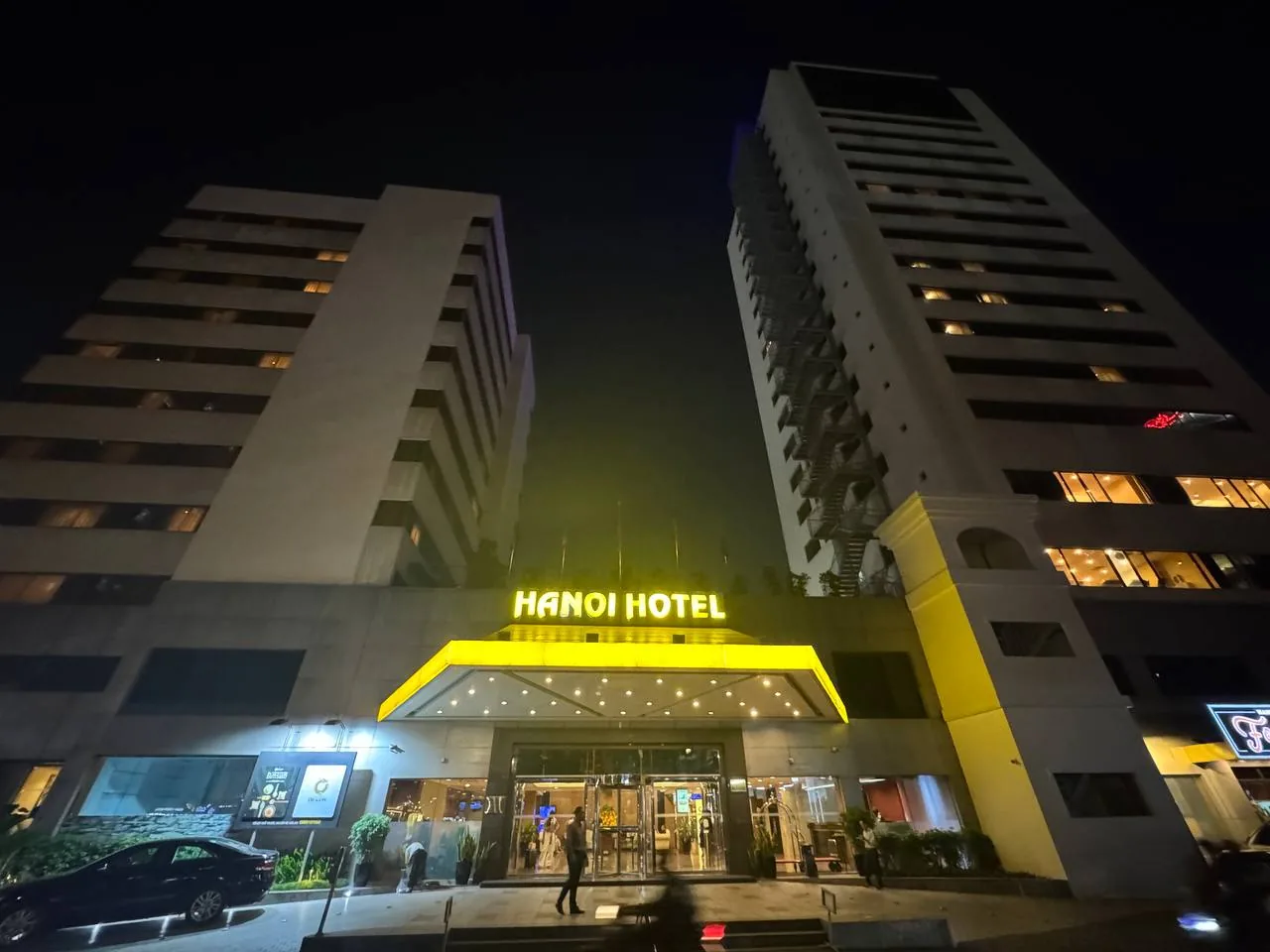 노란색 HANOI HOTEL 간판이 켜진 하노이 호텔 야간 정문