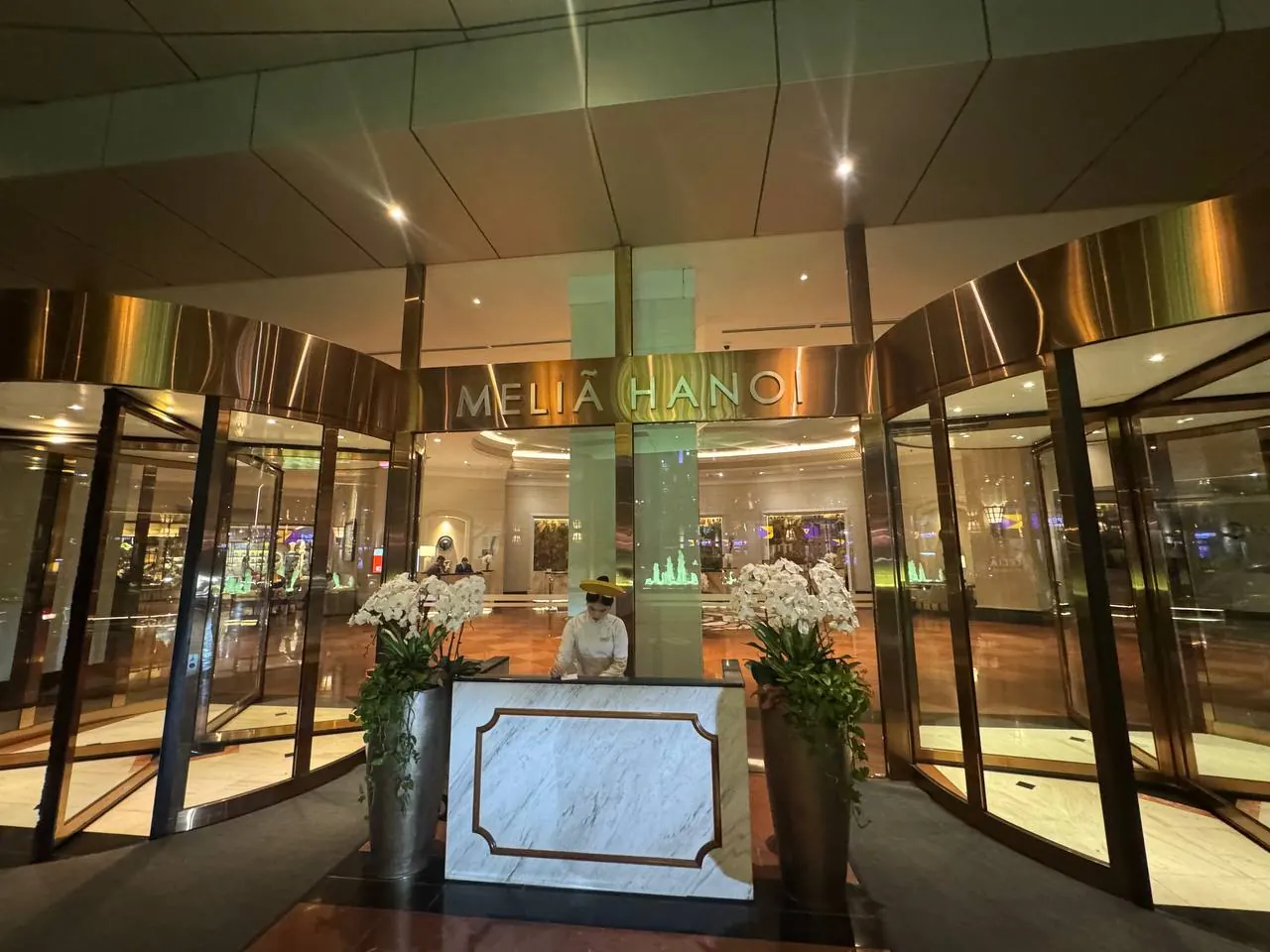 MELIA HANOI 표지와 유리문이 보이는 호텔 정문